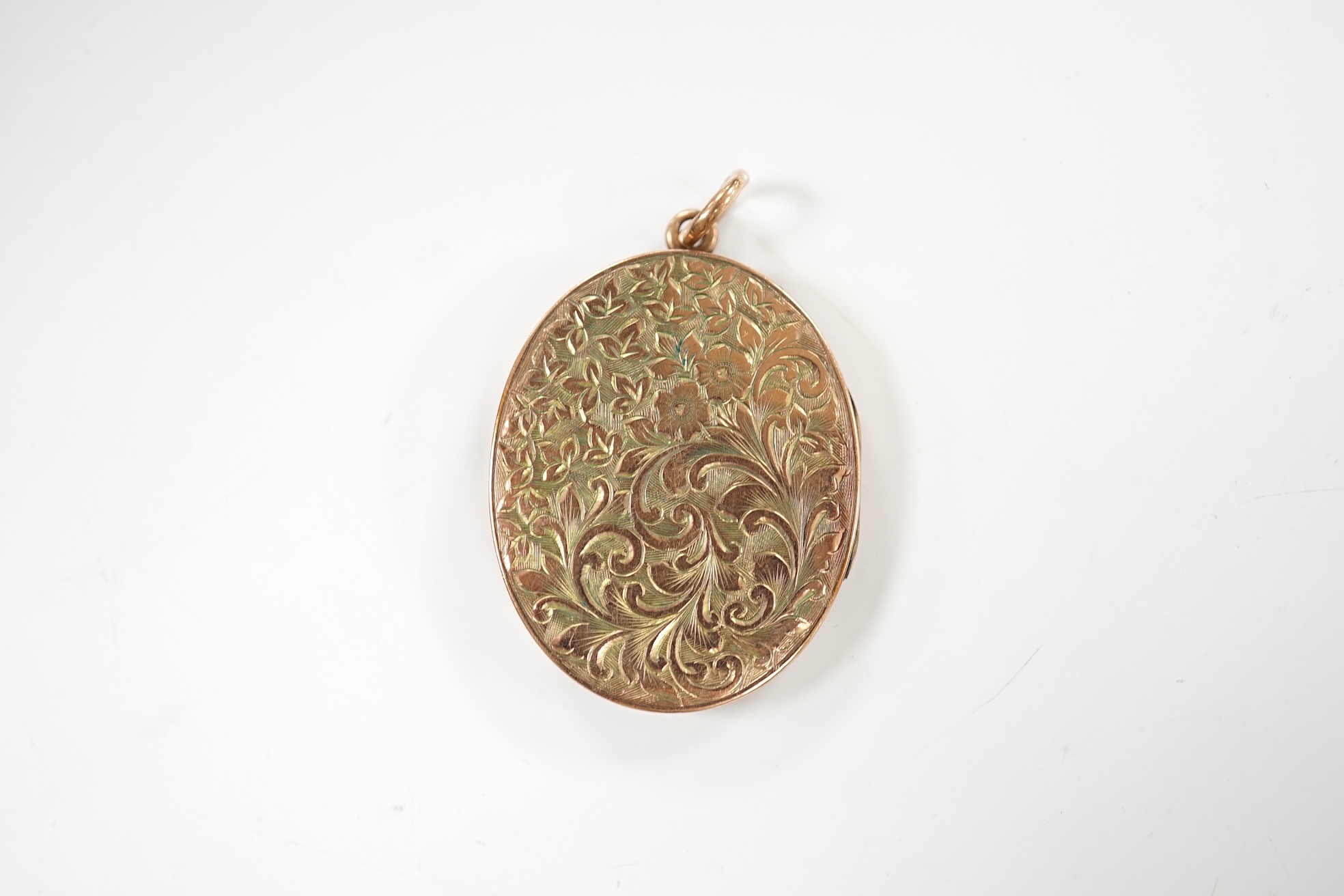 A George V engraved 9ct gold oval locket, 35mm, gross weight 11.7 grams. Condition - fair to good